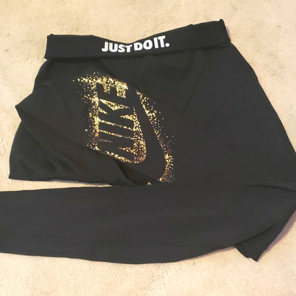 Nike black leggings with gold NIKE decoration on left leg